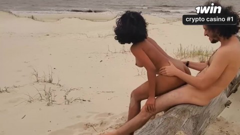 Uma morena voluptuous é fodida na praia por um casal amador e goza em público.